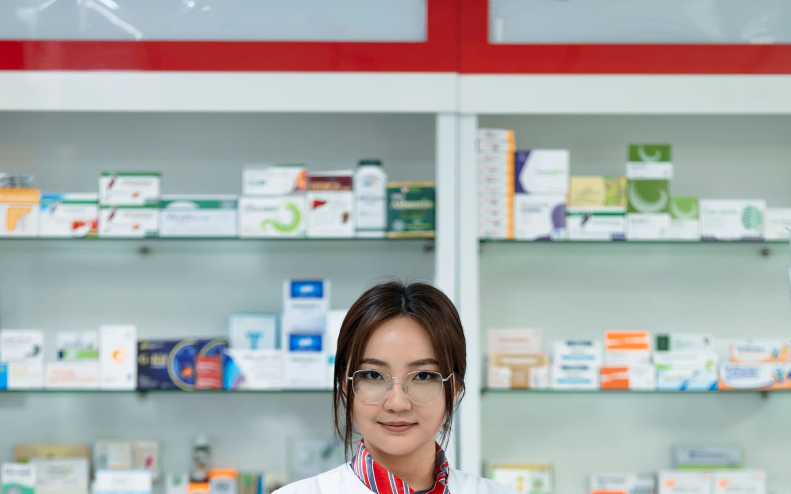 Una farmacista tra gli scaffali della farmacia